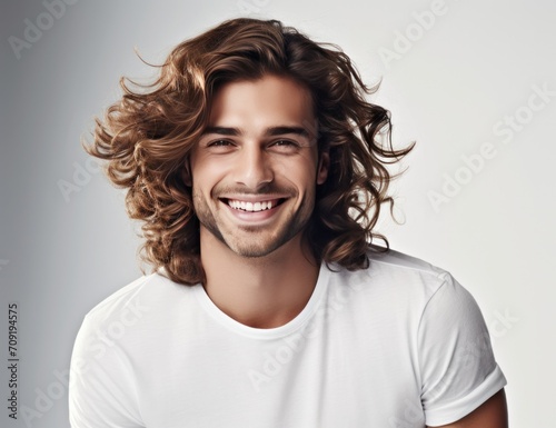 a man with long curly hair smiling while smiling