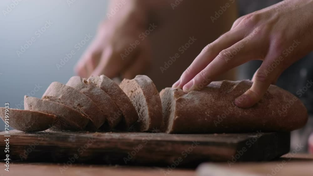 Baker claps his hands with flour while prepare a dough for making homemade bread or pizza on rustic wooden table in traditional bakery. Concept of cookery and bread baking.