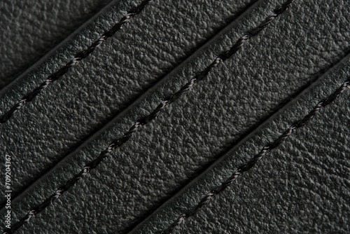 Background is made black leather stitched with black threads.
