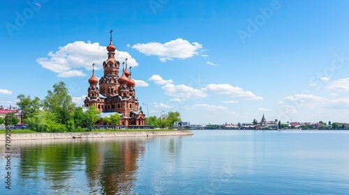 A serene Orthodox church stands tall against the backdrop of a tranquil river, its golden domes reflecting the warm sunlight.