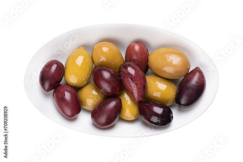Kalamata and green olives with pit, pickled whole, large Greek table olives, in a white oval bowl. Purple fruits picked when ripe, and green olives picked while still unripe, both preserved in brine.