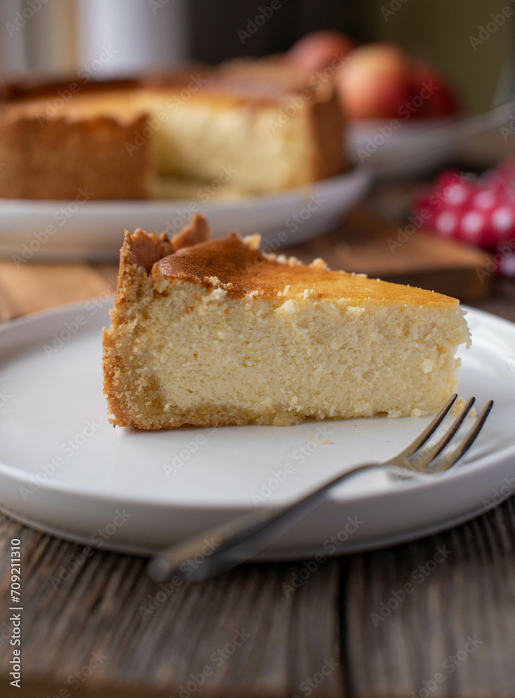 Slice of german cheesecake on rustic and wooden table background