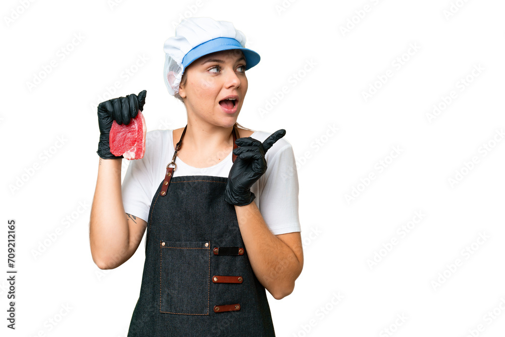 Butcher woman wearing an apron and serving fresh cut meat over isolated chroma key background intending to realizes the solution while lifting a finger up