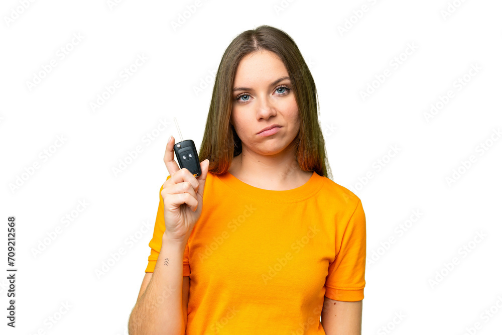 Young woman holding car keys over isolated chroma key background with sad expression Young woman holding car keys over isolated chroma key background with sad expression