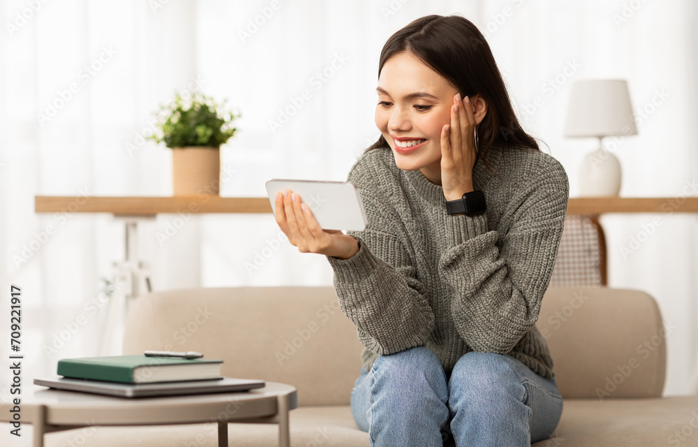 Happy young woman watching video content on smartphone Happy young woman watching video content on smartphone