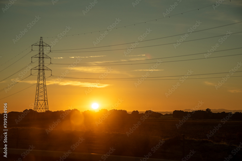 image of a high voltage pylon in silhouette at sunrise