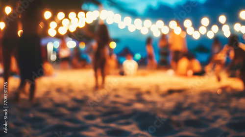 Blurred people having night beach party in summer vacation