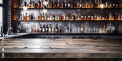 Bar concept featuring bokeh shelves and a grey table top with alcohol bottles in the background.