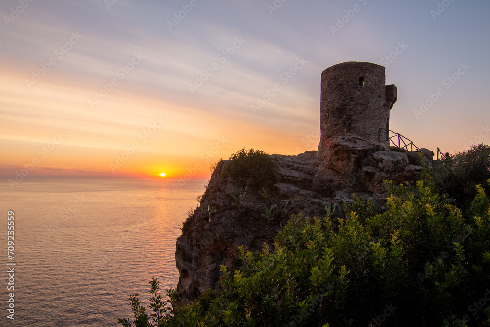 A 16th century watchtower called Torre de Verger on the island of Mallora, Spain. Landscape at sunset over the Mediterranean Sea in the background
