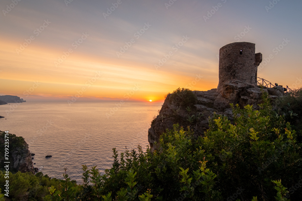 Torre de Verger, on the island of Mallorca, Spain. A 16th century watchtower in the middle of nature with the sunset over the sea in the background