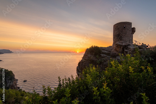 Torre de Verger, on the island of Mallorca, Spain. A 16th century watchtower in the middle of nature with the sunset over the sea in the background photo