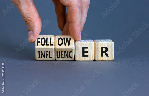 Follower or influencer symbol. Concept words Follower Influencer on wooden cubes. Beautiful grey table grey background. Businessman hand. Business follower influencer concept. Copy space.