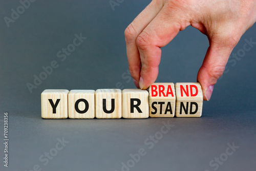 Branding your brand or stand symbol. Concept words Your stand Your brand on beautiful blocks. Beautiful grey background. Businessman hand. Business branding your brand or stand concept. Copy space.