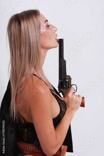 Beautiful woman in black lingerie holding big old revolver