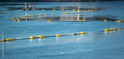 Yellow dredge floats on blue river water