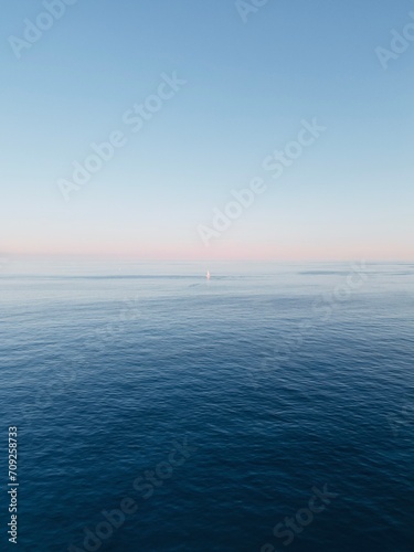 Aerial view boat sailing in the mediterranean sea with the sunset in the background.