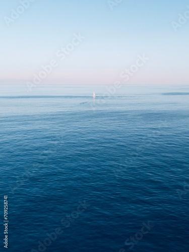 Aerial view boat sailing in the mediterranean sea with the sunset in the background.