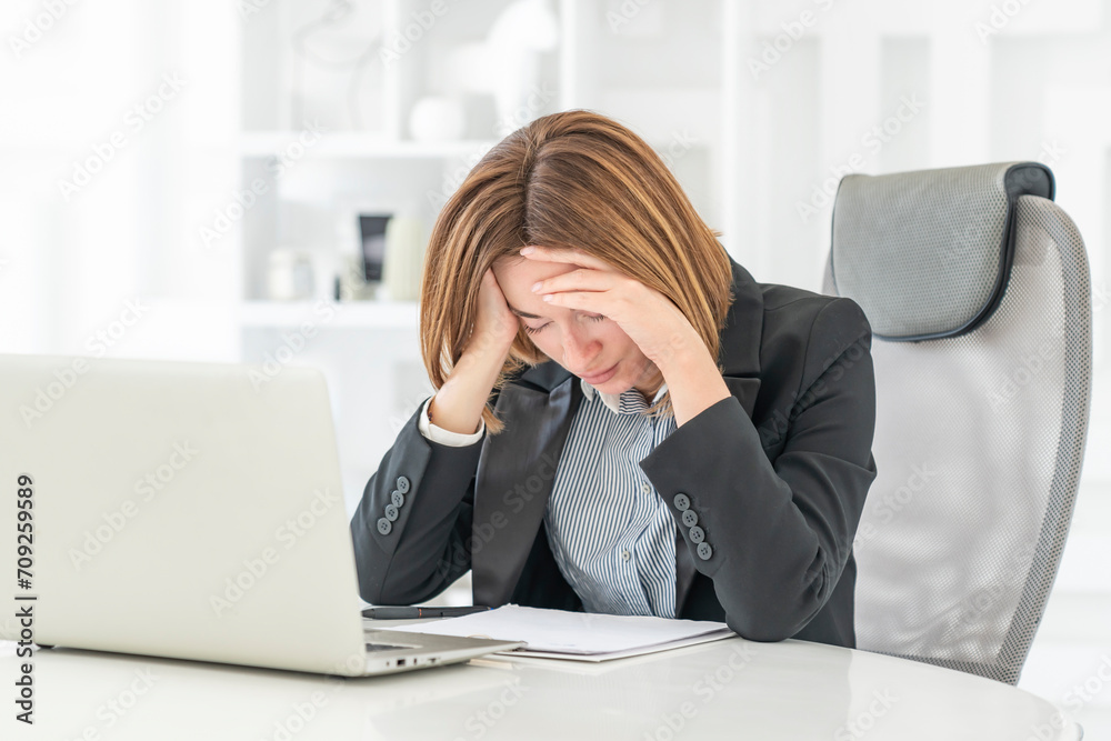 Tired frustrated and overworked business woman sitting in the office and thinking about problems in business Tired frustrated and overworked business woman sitting in the office and thinking about problems in business
