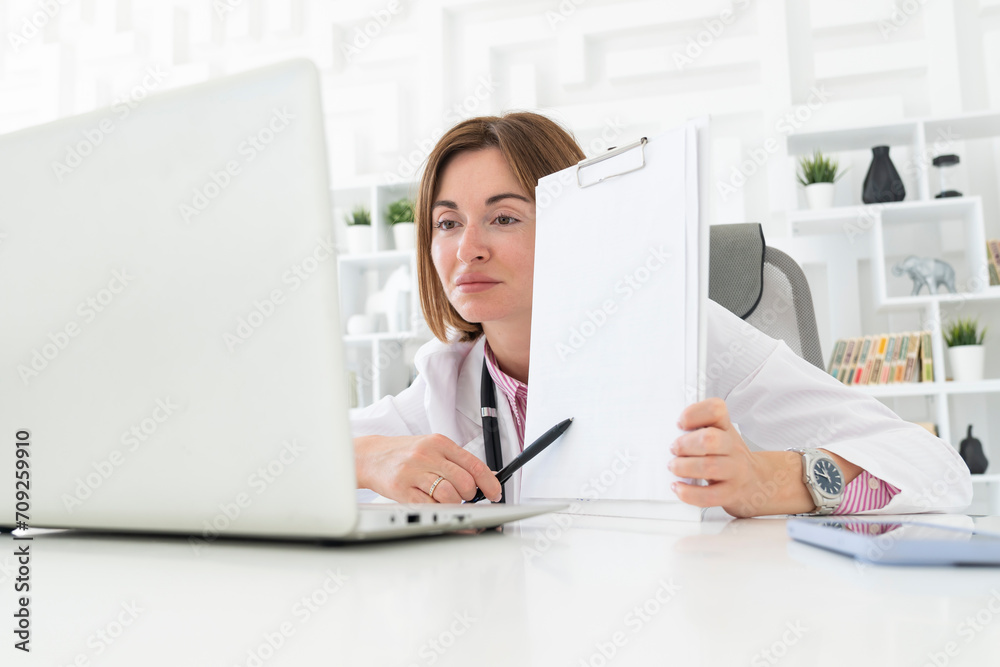 Young attractive female doctor consulting her patients online in the office Young attractive female doctor consulting her patients online in the office