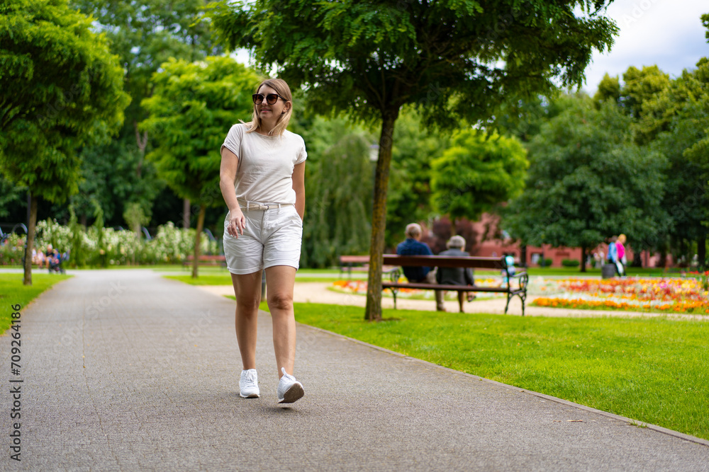 Healthy lifestyle - woman walking in city park Healthy lifestyle - woman walking in city park
