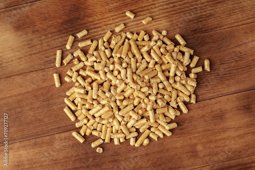 Heap of wooden pellets biofuel on wooden table