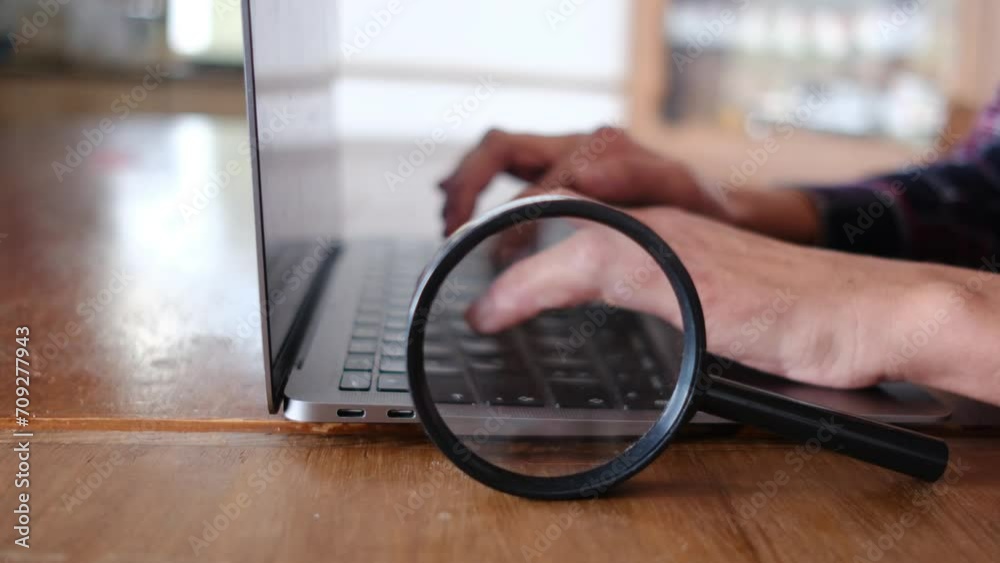  An internet search engine magnifying glass and a computer symbolizing online search and research