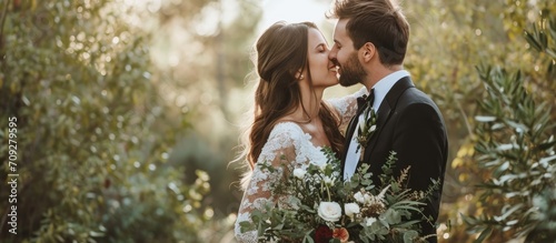 Romantic connection and commitment are celebrated as a couple kisses, smiles, and laughs amidst nature at a wedding ceremony. photo