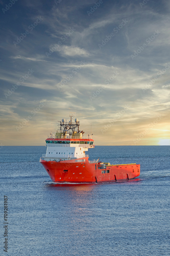 Fototapeta premium Ship arriving at Aberdeen harbour after passing Girdle Ness Lighthouse