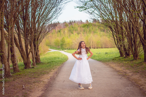 Smiling girl happily celebrating her first communion in a natural and sunny environment