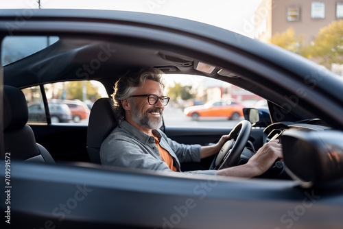 Middle aged man in the middle of the city inside a car and driving © luismolinero