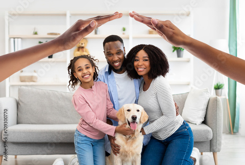 Happy black family posing with dog at home photo