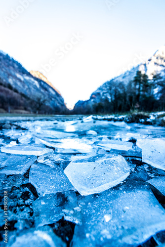 broken ice on the ground with mountains in the background in switzerland