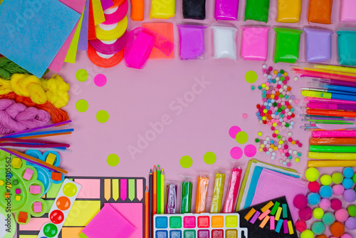 Multicolored art background on pink surface.Girly pastel pink design. Flat lay workspace. Artist workspace mock up.
