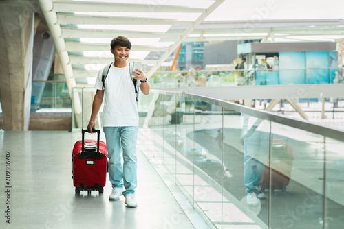 Positive Asian Traveler Man Using Travel App On Smartphone