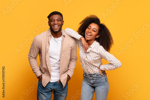 Εκτύπωση καμβά Cheerful young black couple laughing together against yellow background