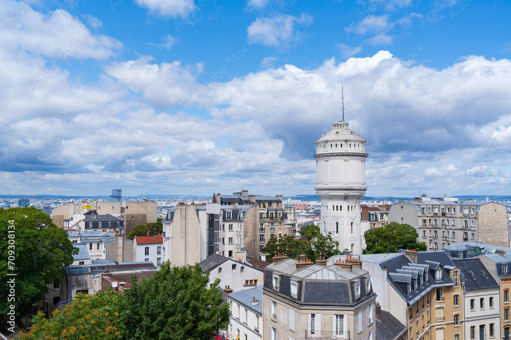 paris cityscape and landmark water tower or chateau d'eau de montmartre above horizon