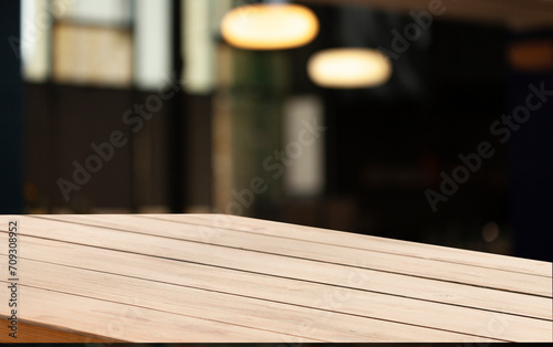 blurred background of bar and dark brown workspace desk made of retro wood