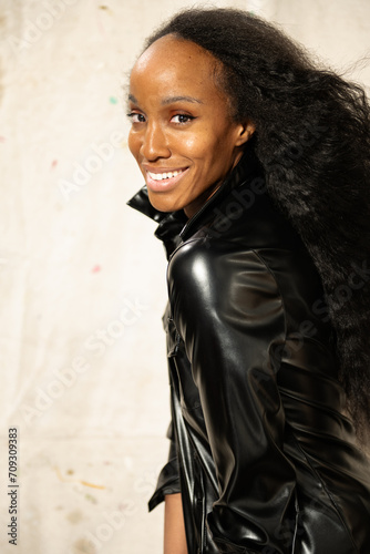 Tall African America Woman in leather shirt poses in a studio setting