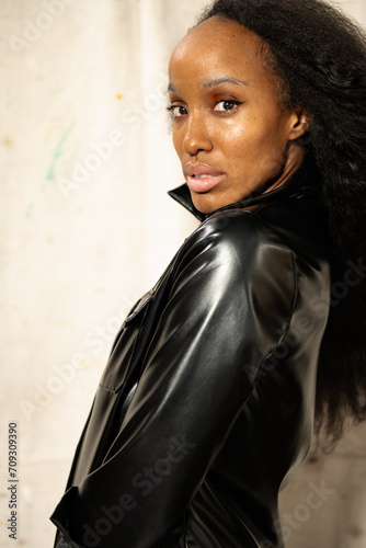Tall African America Woman in leather shirt poses in a studio setting