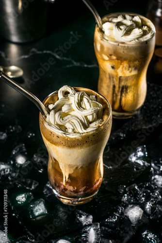 A fully prepared Greek frappe in a tall glass, crowned with a generous amount of whipped cream, ready to be enjoyed on a sweltering day