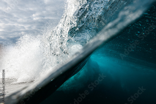 Crisp underwater view of a wave breaking above