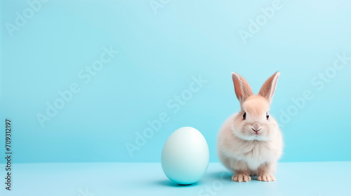 Cute toy little bunny and easter eggs on pastel blue background with place for text. Happy easter card.