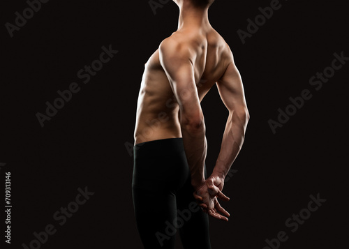 Silhouette of a slender muscular man doing sports in the gym. Sports and healthy lifestyle.