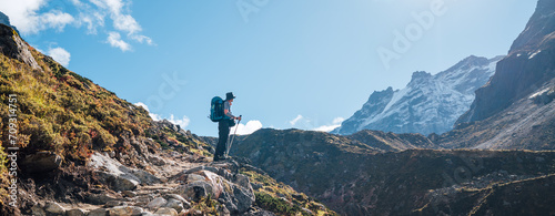 Young hiker backpacker man enjoying valley view in Makalu Barun Park route near Khare during high altitude acclimatization walk. Mera peak trekking route, Nepal. Active vacation concept image photo