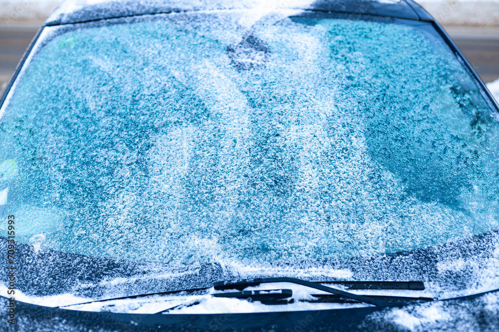 Icy windshield, wipers and hood. Winter car difficulties concept.