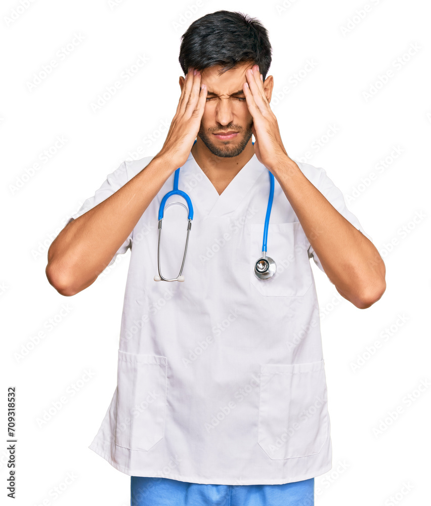 Young handsome man wearing doctor uniform and stethoscope suffering from headache desperate and stressed because pain and migraine. hands on head. Young handsome man wearing doctor uniform and stethoscope suffering from headache desperate and stressed because pain and migraine. hands on head.