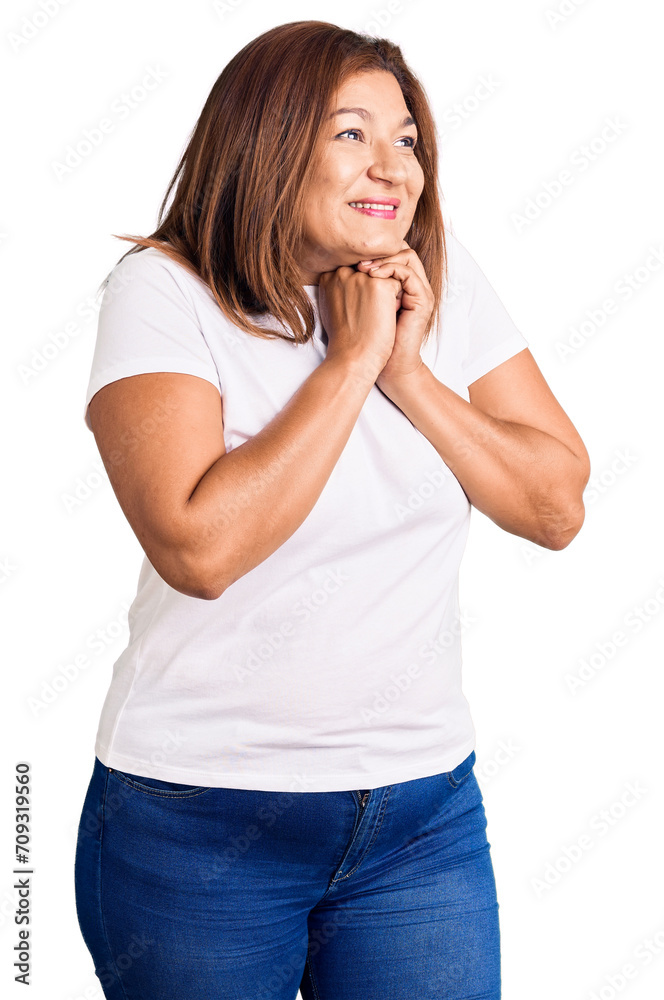 Middle age latin woman wearing casual white tshirt laughing nervous and excited with hands on chin looking to the side Middle age latin woman wearing casual white tshirt laughing nervous and excited with hands on chin looking to the side