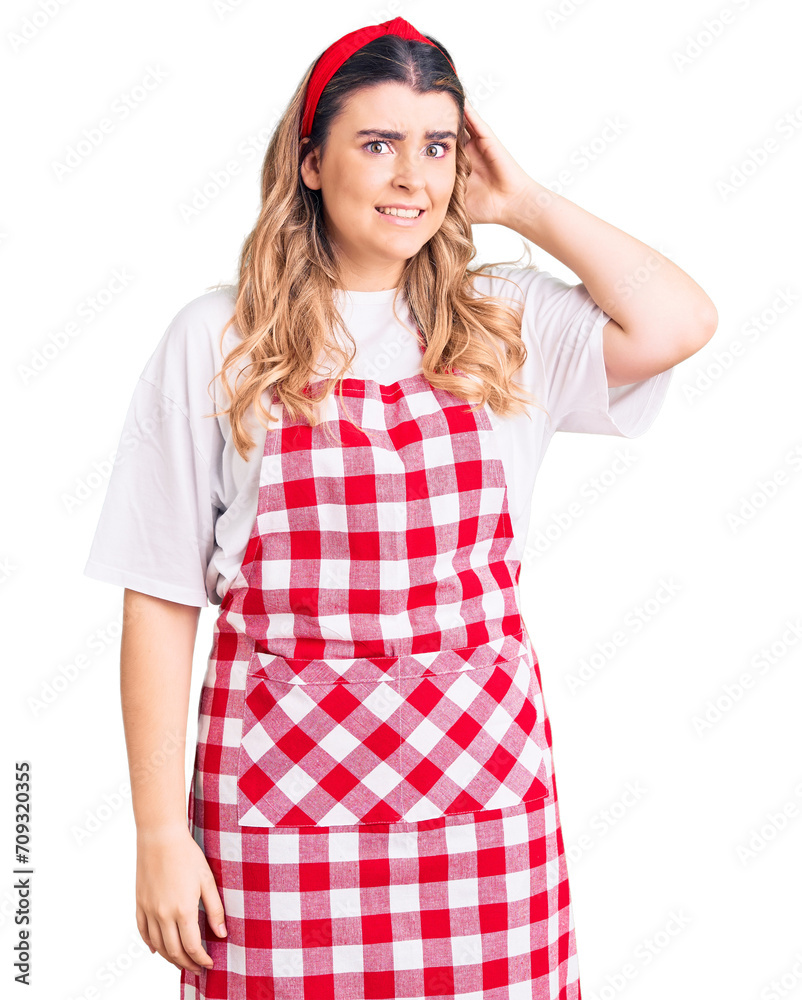 Young caucasian woman wearing apron confuse and wonder about question. uncertain with doubt, thinking with hand on head. pensive concept. Young caucasian woman wearing apron confuse and wonder about question. uncertain with doubt, thinking with hand on head. pensive concept.