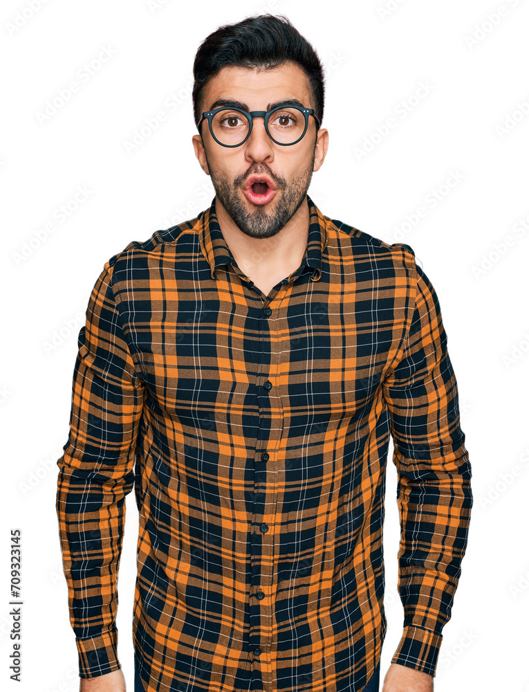 Hispanic man with beard wearing casual clothes and glasses scared and amazed with open mouth for surprise, disbelief face Hispanic man with beard wearing casual clothes and glasses scared and amazed with open mouth for surprise, disbelief face