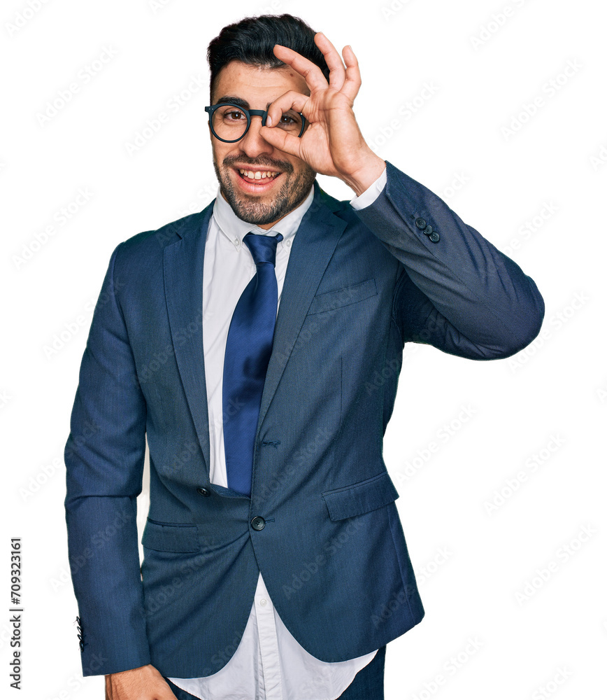 Hispanic man with beard wearing business suit and tie smiling happy doing ok sign with hand on eye looking through fingers Hispanic man with beard wearing business suit and tie smiling happy doing ok sign with hand on eye looking through fingers